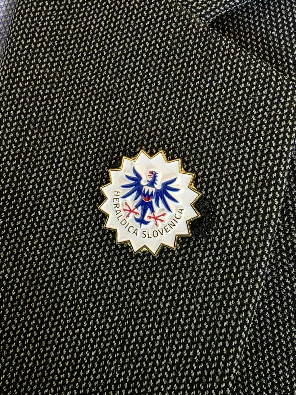 Članska značka Društva Heraldica Slovenica na suknjiču. Značke se vedno nosijo na levem zavihku suknjiča - v bližini srca.